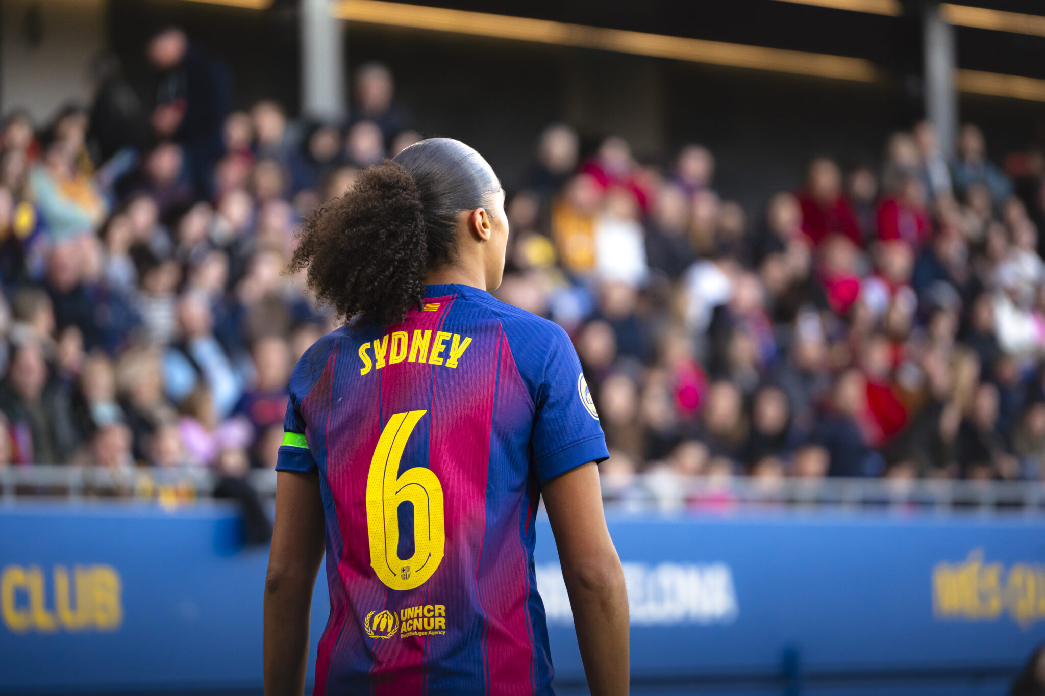 Sydney Joy jugadora del FC Barcelona Femenino de espaldas observa el desarrollo del partido desde el terreno de juego.